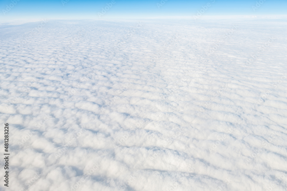 Reykjavik, Iceland flying above island with cloudscape aerial high angle view above of cloudy landscape horizon with blue sky and pattern of white fluffy clouds from airplane Reykjavik, Iceland flying above island with cloudscape aerial high angle view above of cloudy landscape horizon with blue sky and pattern of white fluffy clouds from airplane