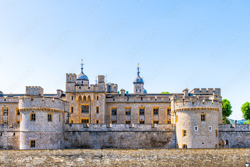 Tower of London stone fortress fort palace and prison by bridge exterior facade view and blue sky in sunny summer