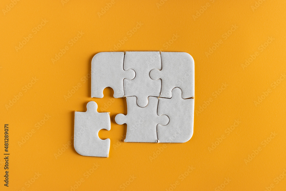 top view of white unfinish jigsaw puzzle on yellow orange background. business concept. top view of white unfinish jigsaw puzzle on yellow orange background. business concept.