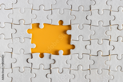 Canvastavla top view of unfinished white puzzle pieces on yellow or orange background