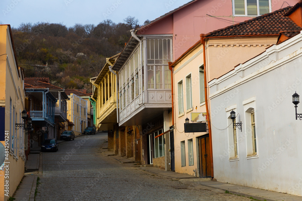 Traditional old houses with carved balconies on narrow winding streets in small Georgian town of Sighnaghi in springtime