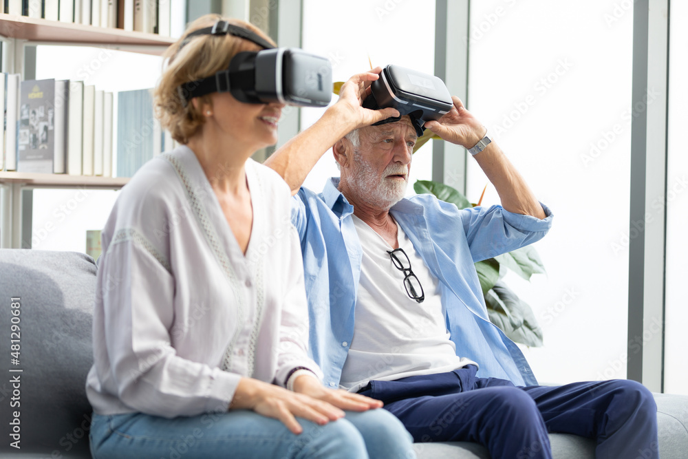 senior man wearing virtual reality headset or VR and looking something on the sofa senior man wearing virtual reality headset or VR and looking something on the sofa