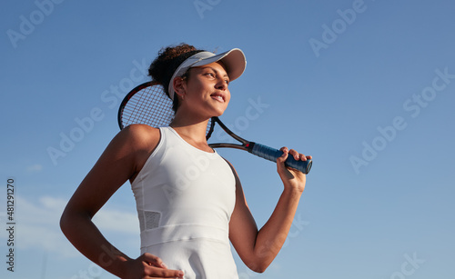 Black sportswoman with tennis racket against sky © kegfire