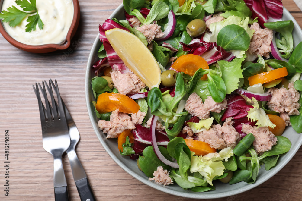 Bowl of delicious salad with canned tuna and vegetables served on wooden table, flat lay Bowl of delicious salad with canned tuna and vegetables served on wooden table, flat lay