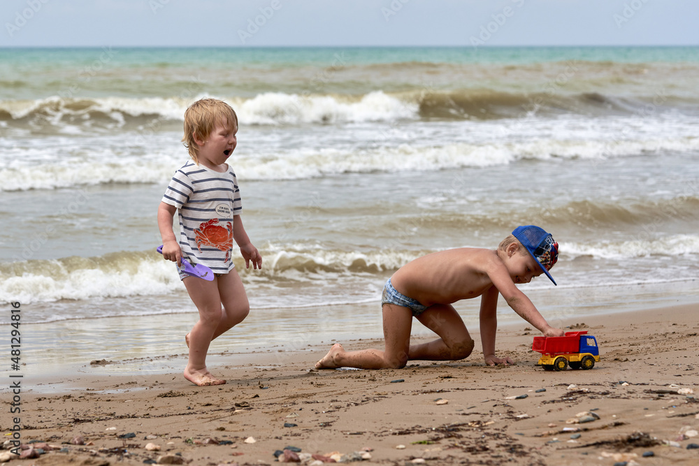 Two little boys are playing on the seashore Two little boys are playing on the seashore