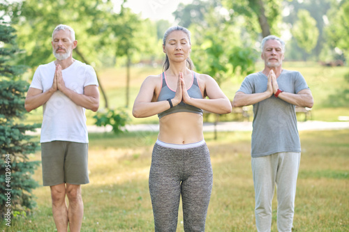 Group of poeple meditating together in park