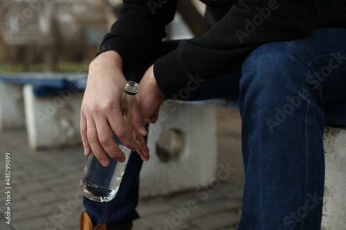 Addicted man with alcoholic drink on bench outdoors  closeup