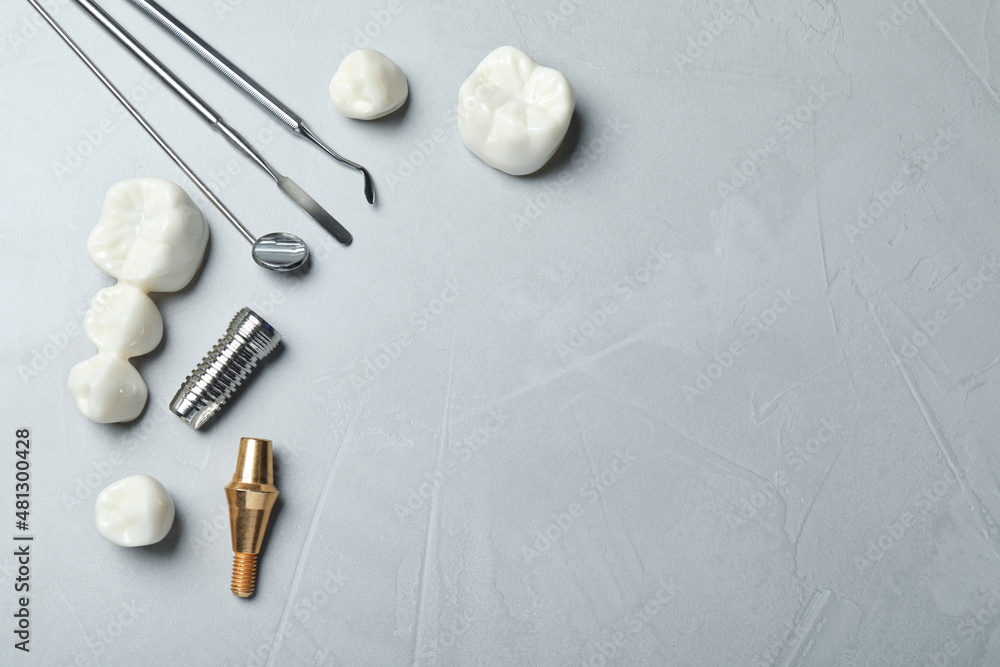 Tableau sur toile Post, abutment and different crowns of dental implant near medical tools on grey background, flat lay