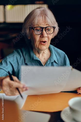 Portrait of an elderly woman sitting in a cafe with a cup of coffee and a laptop Freelancer works unaltered