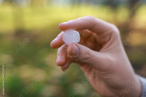 Woman holding hail grain after thunderstorm outdoors, closeup © New Africa