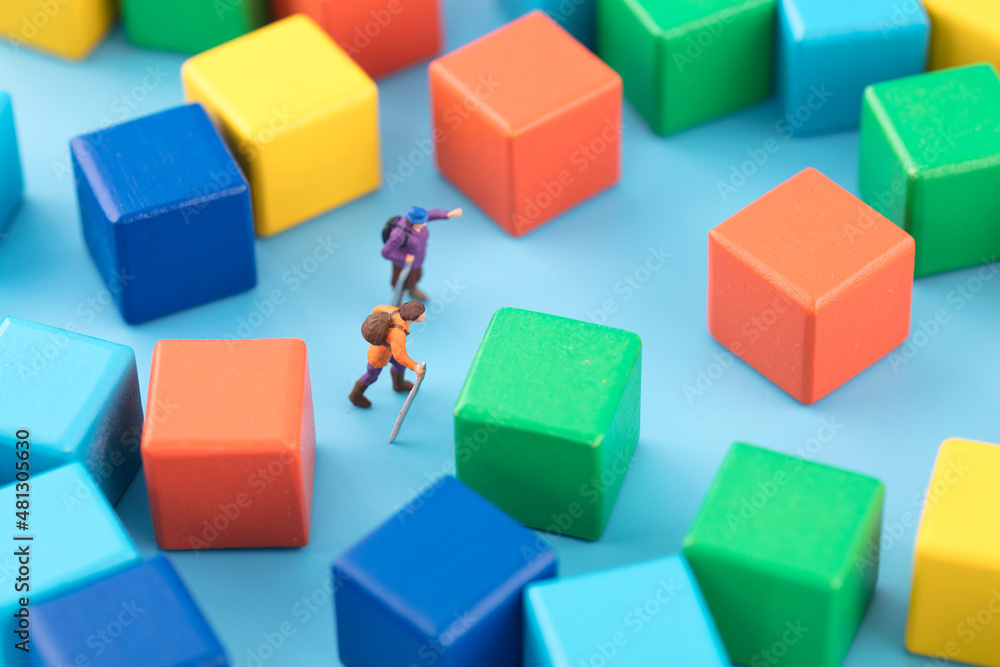 Miniature creative pedestrian lost in the building block maze Miniature creative pedestrian lost in the building block maze