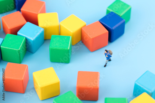 Miniature creative pedestrian lost in the building block maze