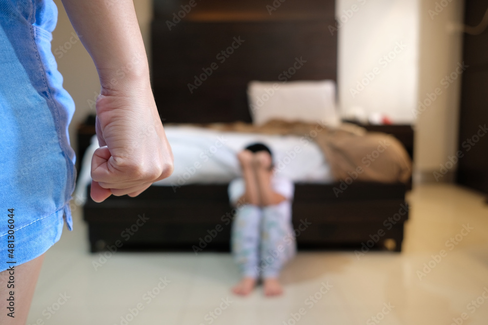 Woman acting to hit a child with her fist as domestic violence and abuse concept image