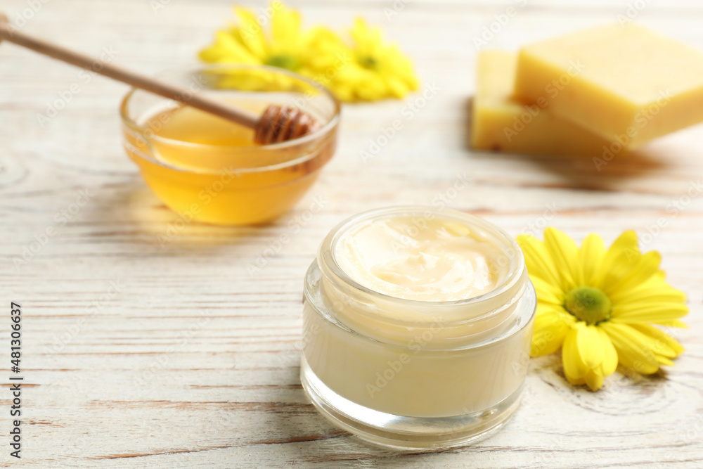 Cream with natural beeswax component on white wooden table, closeup view Cream with natural beeswax component on white wooden table, closeup view