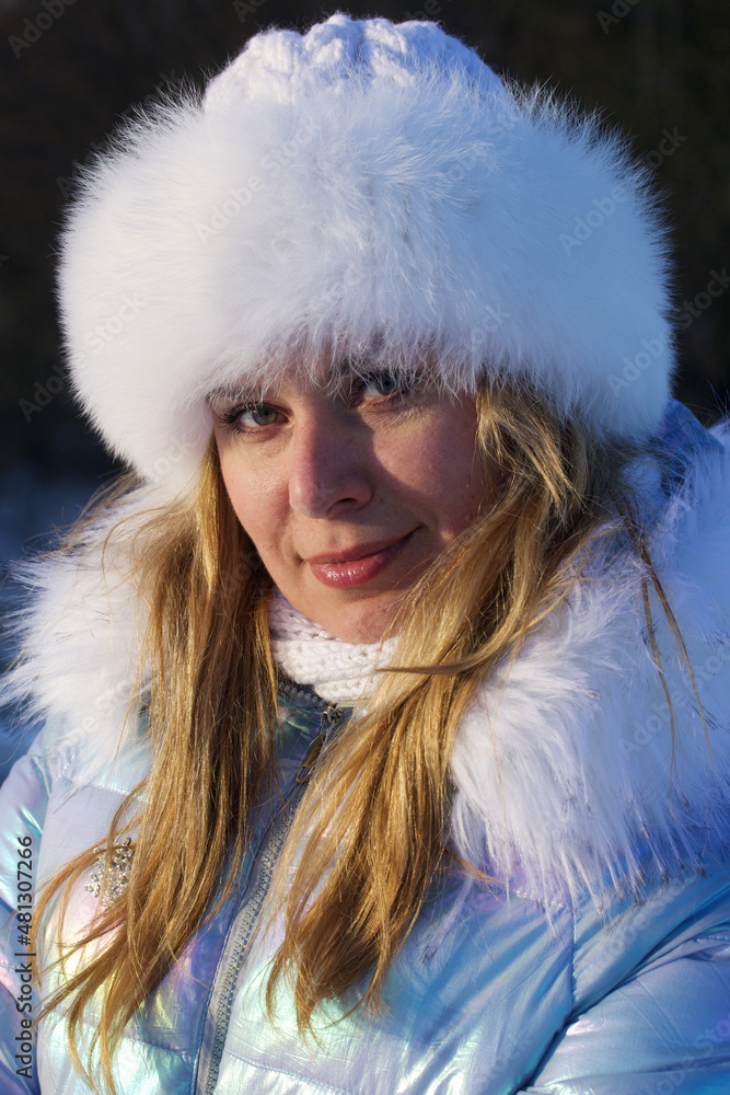 Portrait of a girl in winter clothes. Woman posing on a walk in a winter park. Facial portrait. Portrait of a girl in winter clothes. Woman posing on a walk in a winter park. Facial portrait.
