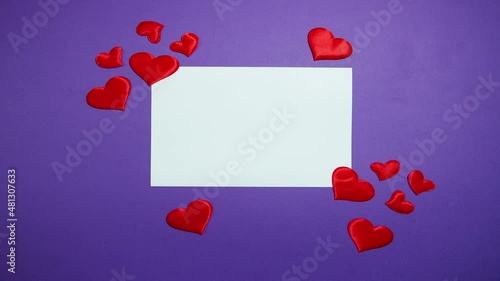 Empty sheet of paper and red hearts on a purple background. Stop motion animation.