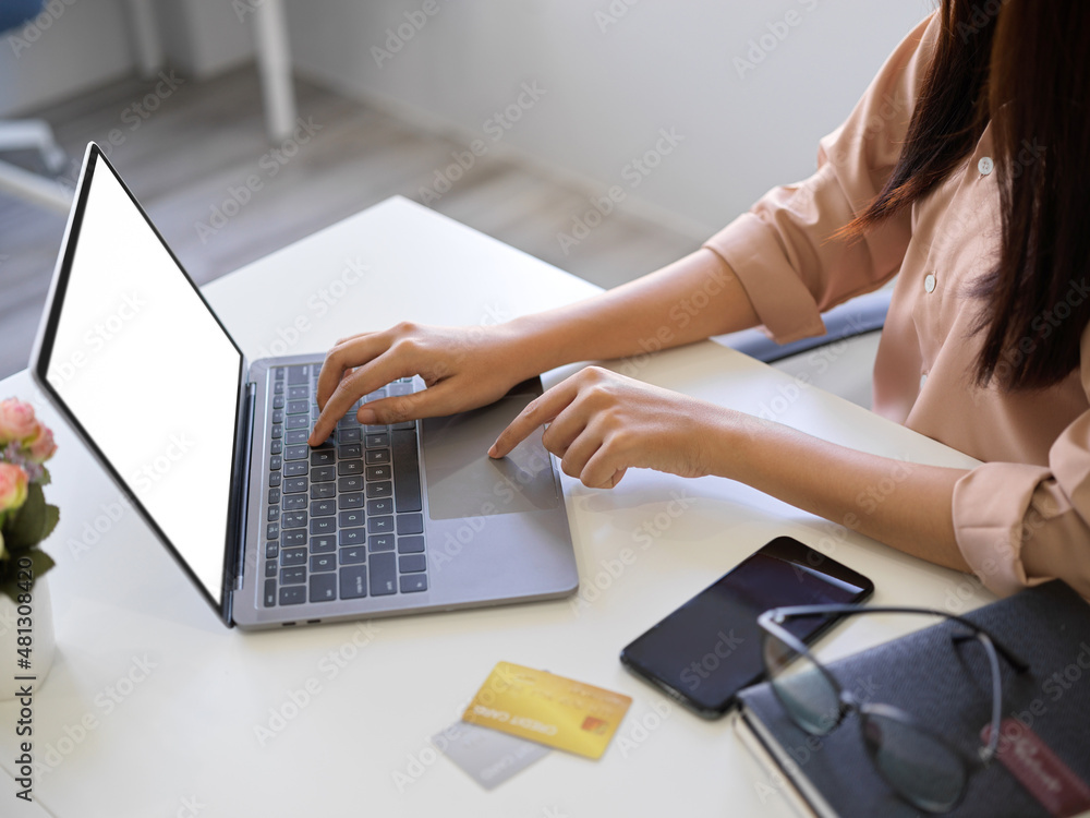 Fototapeta premium Close-up image of a businesswoman typing on laptop keyboard.