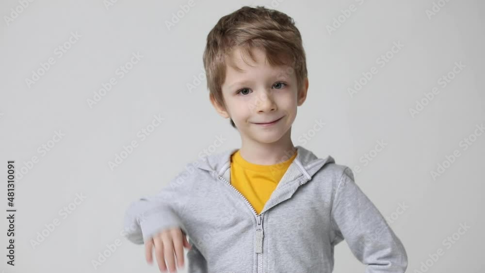 Smiling boy posing isolated on white wall background. Looking at camera showing thumbs up gesture. Smiling boy posing isolated on white wall background. Looking at camera showing thumbs up gesture.