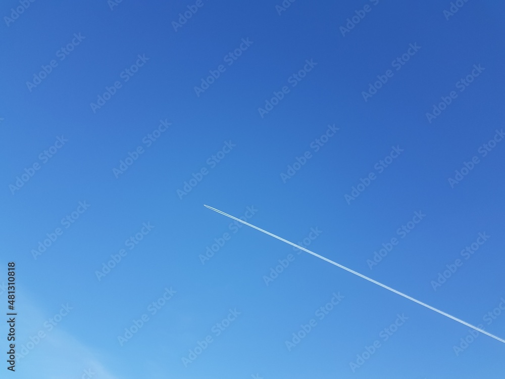 White trail from an airplane in the blue sky White trail from an airplane in the blue sky