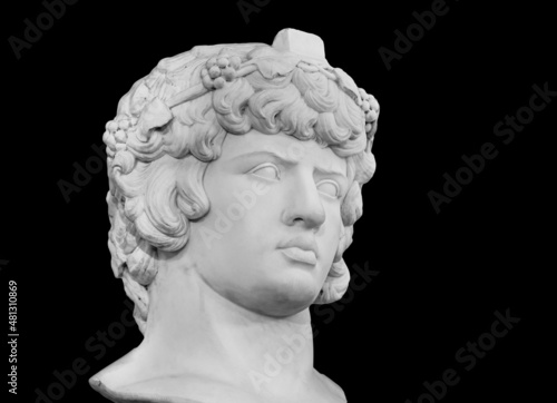 Gypsum copy of famous ancient statue Antinous head isolated on a black background. Plaster antique sculpture young man face. Renaissance epoch. Portrait