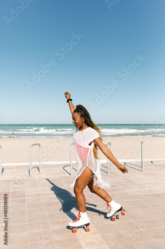 Black woman skating on the beach
