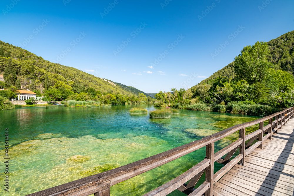 Obraz premium Waterfalls at Skradinski Buk, national nature park Krka, Croatia. Flowing water in beautiful nature, green plants and trees. Sunny summer day.