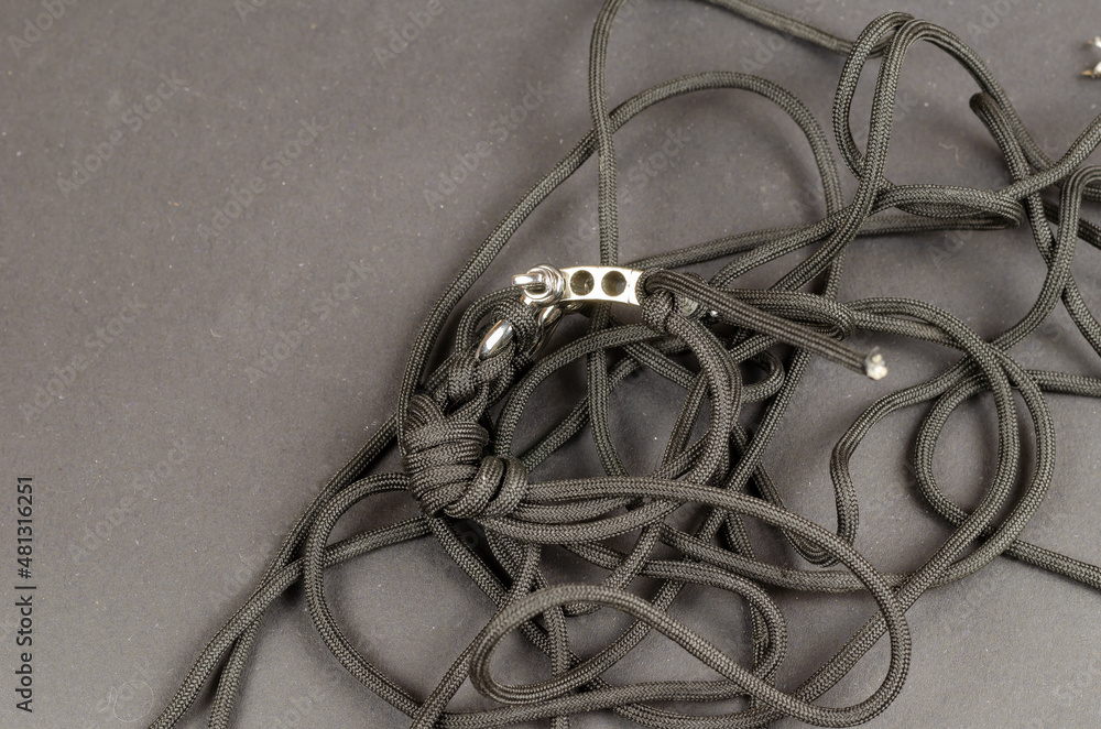 Paracord with braided clasp and rigging strap lying chaotically. Paracord with braided clasp and rigging strap lying chaotically.