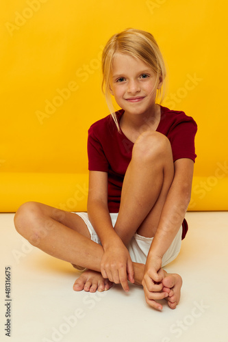 little girl on the floor posing yellow background © Tatiana