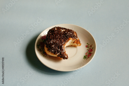 close up chocolate donut flavour on plate. bite. flatlay 