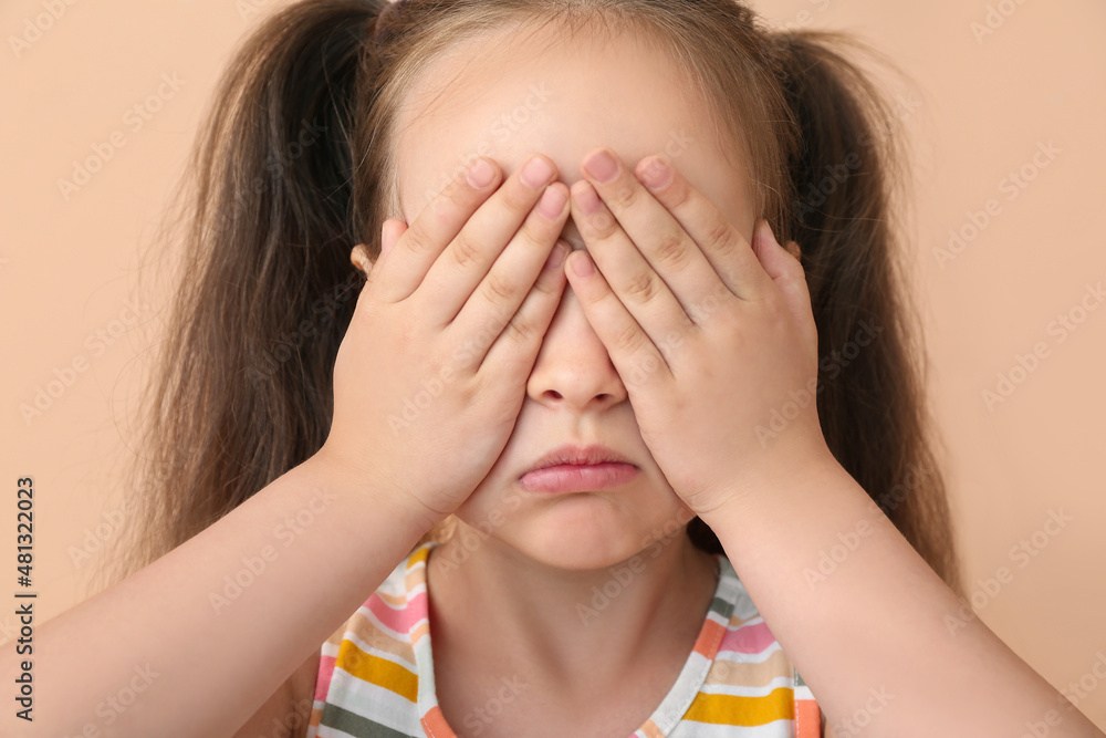 Crying little girl on beige background, closeup Crying little girl on beige background, closeup