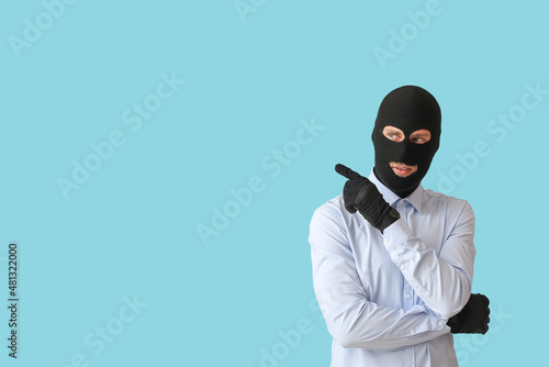 Fraudster in balaclava poin...