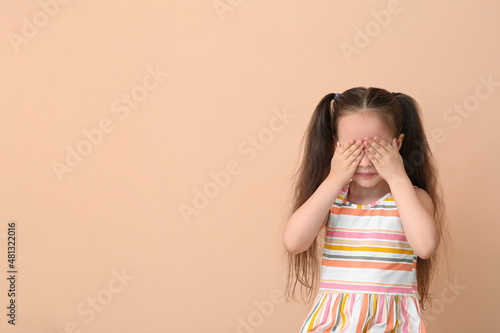 Crying little girl on beige...