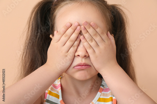 Crying little girl on beige...