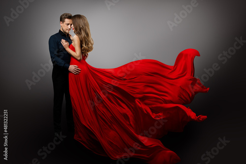 Wallpaper Mural Romantic Couple in Love dancing. Man in Black Shirt Embracing Mysterious Girl in Flying Red Dress. Fashion Woman in Long Waving Gown and Boyfriend over Gray Background Torontodigital.ca