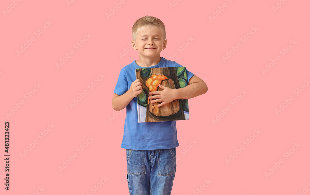 Adorable little boy with book on pink background Adorable little boy with book on pink background