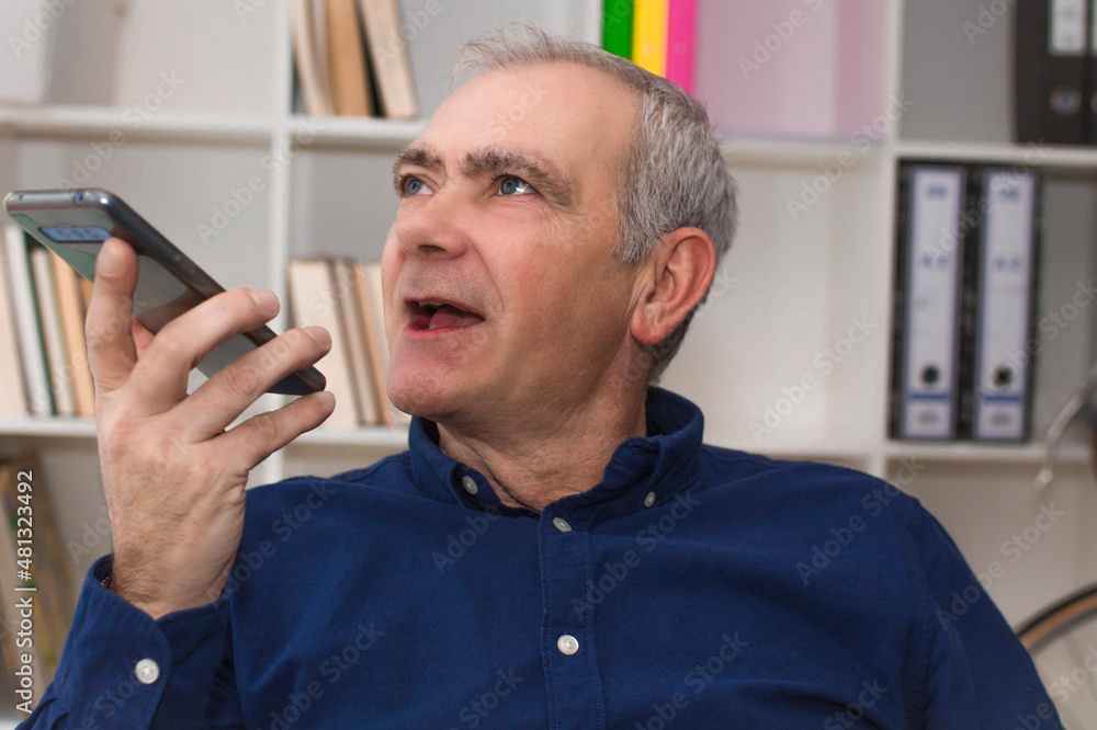 mature man talking into smartphone mature man talking into smartphone