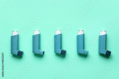Modern asthma inhalers on green background