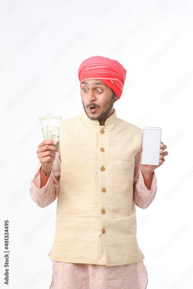 Young indian farmer showing smartphone and money on white background. Young indian farmer showing smartphone and money on white background.