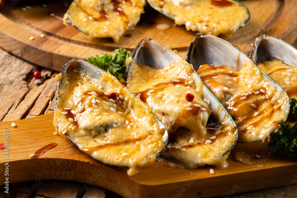 Mussels baked with cheese, teriyaki sauce and sesame seeds. Close-up. Mussels baked with cheese, teriyaki sauce and sesame seeds. Close-up.