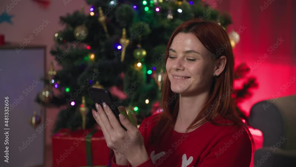 gifts online, beautiful young woman buys goods in an online store for New Years sale, shows screen of smartphone with green chroma key and holds gift box in her hands while sitting background of gifts online, beautiful young woman buys goods in an online store for New Years sale, shows screen of smartphone with green chroma key and holds gift box in her hands while sitting background of