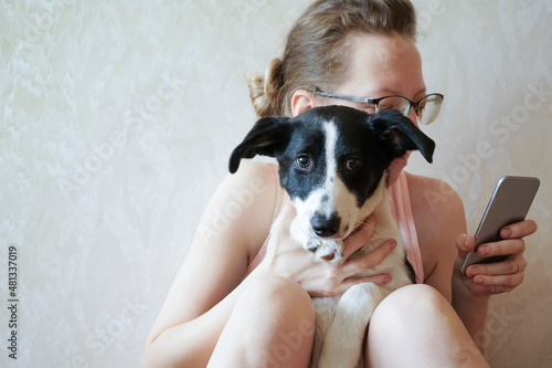 Fotografia Midsection Of Woman Holding Dog While Sitting At Home