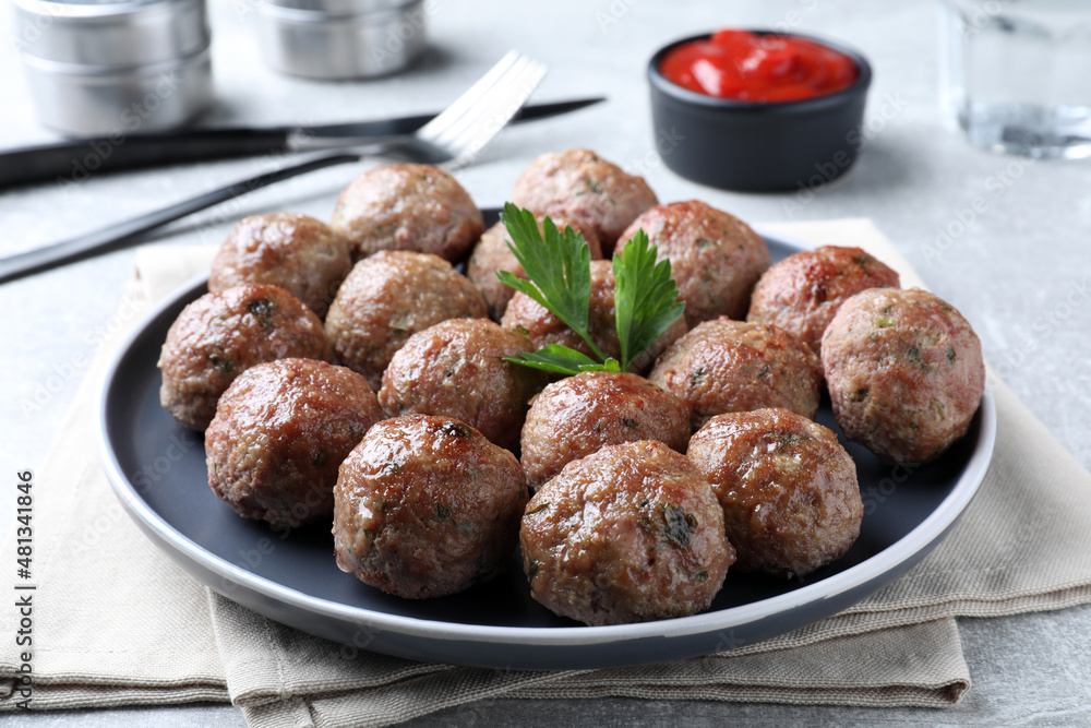 Tasty cooked meatballs with parsley on light grey table, closeup Tasty cooked meatballs with parsley on light grey table, closeup