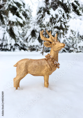 Golden deer made of wood looking for love in snowy forest