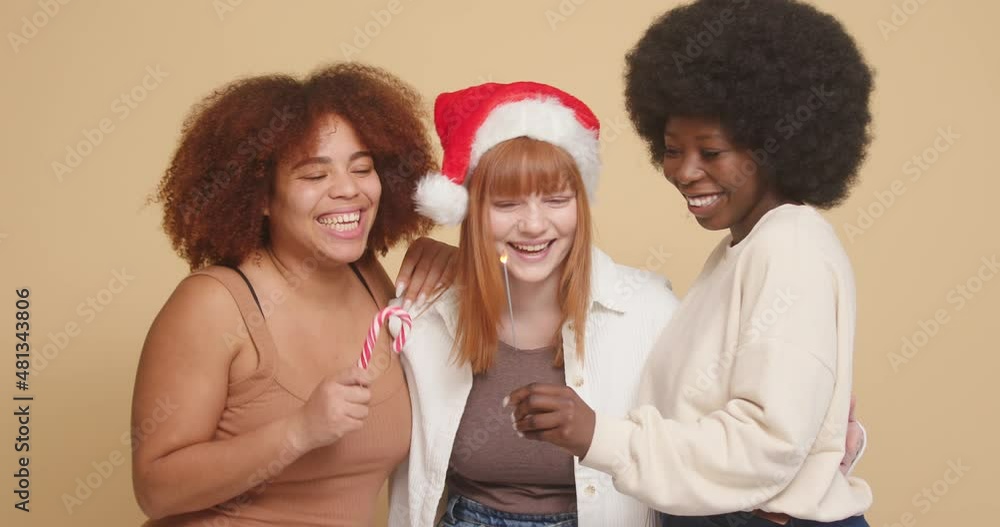 Mixed race women friends dance and laugh celebrating Christmas eve Mixed race women friends dance and laugh celebrating Christmas eve