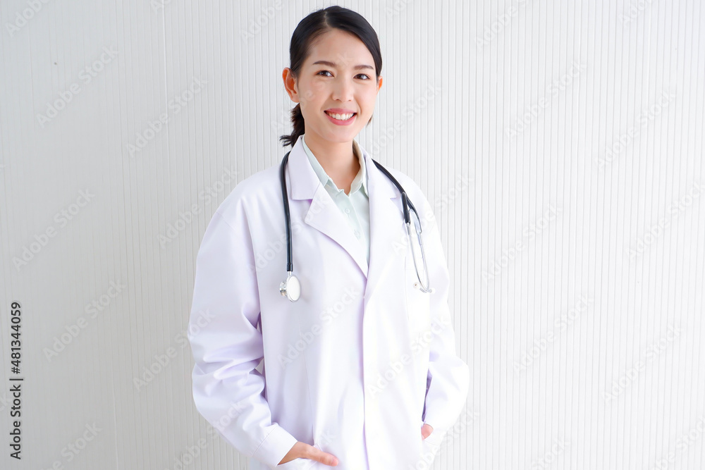 Smiling Asian female doctor puts a stethoscope on her shoulder. wearing white lab coat on gray background. Smiling Asian female doctor puts a stethoscope on her shoulder. wearing white lab coat on gray background.