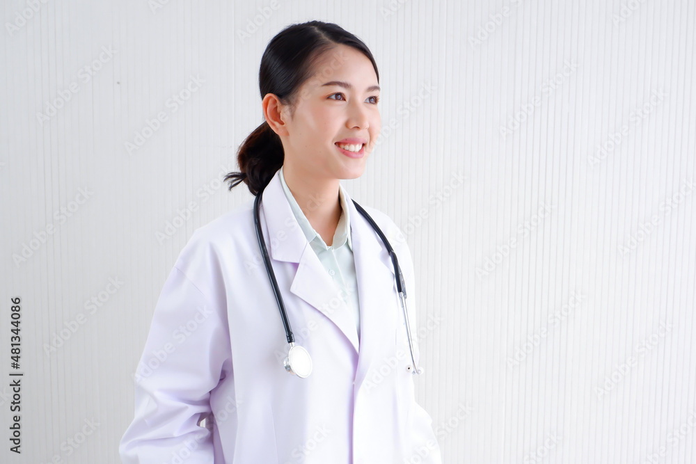 Smiling Asian female doctor puts a stethoscope on her shoulder. wearing white lab coat on gray background. Smiling Asian female doctor puts a stethoscope on her shoulder. wearing white lab coat on gray background.