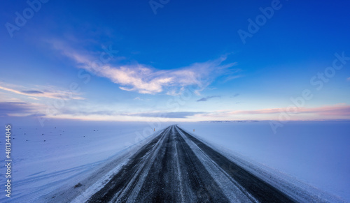Empty road in winter landscape to the sky