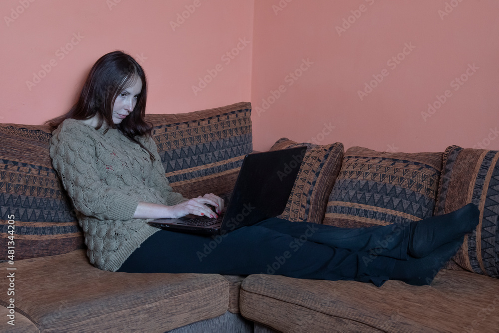woman on sofa at home working on laptop woman on sofa at home working on laptop