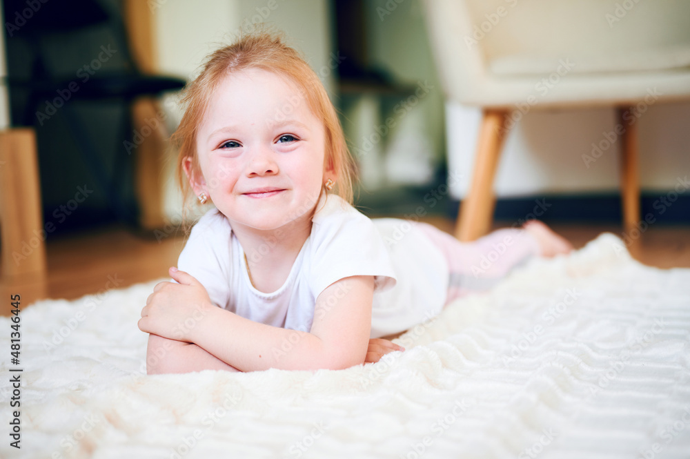 Cute little girl lying on the floor at home and smile Cute little girl lying on the floor at home and smile
