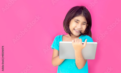Happy asian girl learning with tablet and internet on pink colour